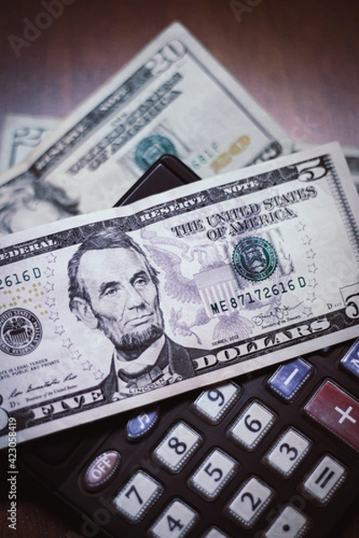 Obraz Five dollar bill with a calculator and twenty dollar bill background