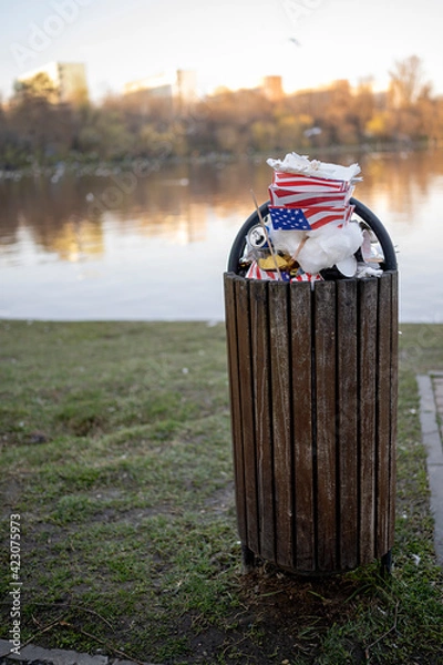 Obraz Overflowing waste from the full container placed in a public park.