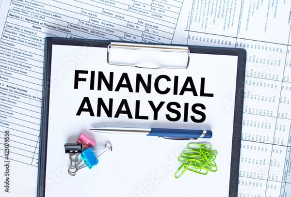 Fototapeta Text Financing Analysis on the folder that is located on the financial reports with calculator and stationery clips