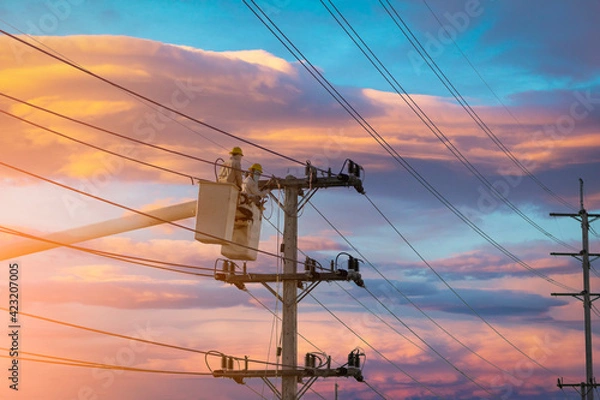 Fototapeta electrician works on bucket car to maintain high voltage transmission lines.