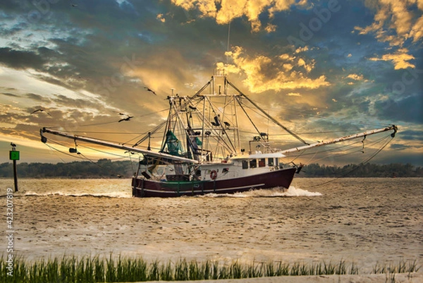 Obraz A shrimp boat entering Charleston, SC harbor in the evening.