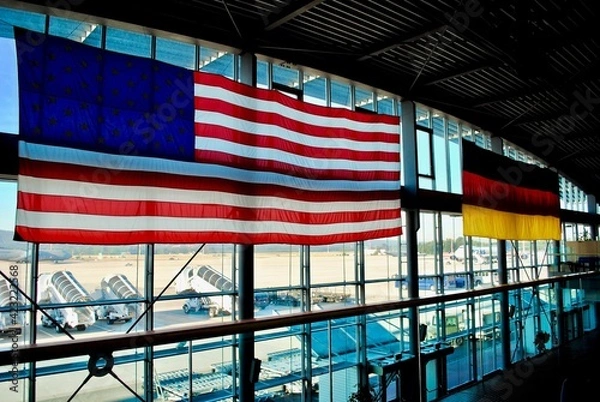 Fototapeta Ramstein, Germany: Ramstein Air Base PAX Passenger terminal. American and German flags hang in the main gateway for the Kaiserslautern Military Community of Americans living in Germany.
