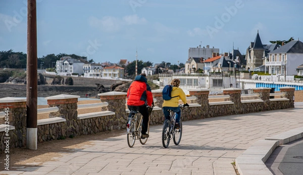Obraz Vendée, FRANCE; March 14, 2021: Photo of a couple cycling on the Boisvinet cyclabe track in Saint Gilles Croix de Vie. 