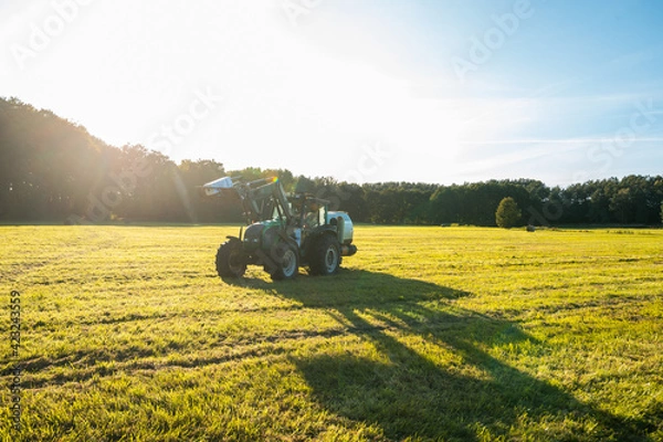 Obraz Traktor foliert Strohballen ein