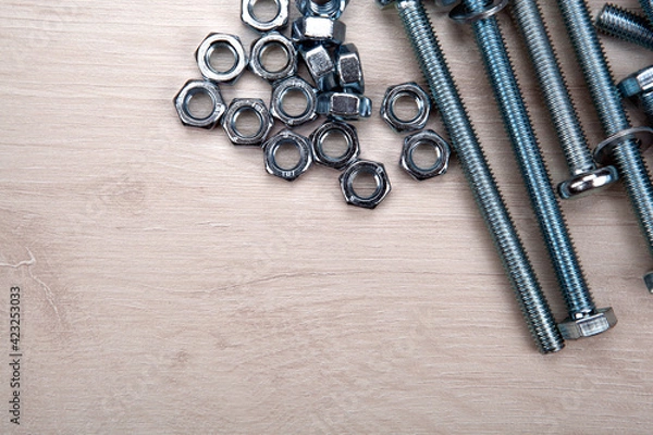 Obraz nuts screws fastening materials a lot closeup on a wooden background