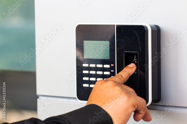 Fototapeta Staff push down electronic control machine with finger scan to access the door of control room or data center.