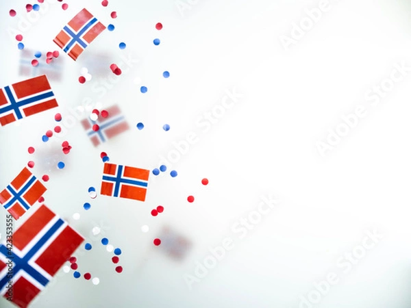 Fototapeta Norwegian independence day, Constitution day, may 17. holiday of freedom, victory and memory. concept of patriotism and faith. paper confetti and mini flags on white foggy background
