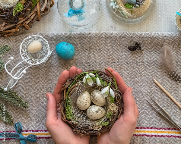 Fototapeta A nest with three white Easter eggs and bunny ears at home on Easter day. Celebrating Easter at spring. Painting eggs.