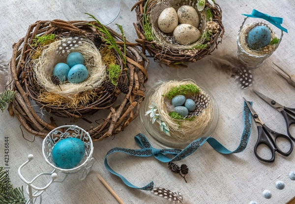 Fototapeta Pastel three colored easter eggs in the nest with cuckooflower in the background isolated on white