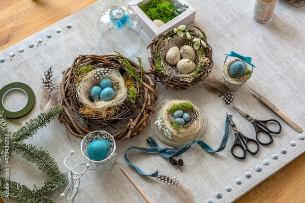 Fototapeta Pastel three colored easter eggs in the nest with cuckooflower in the background isolated on white