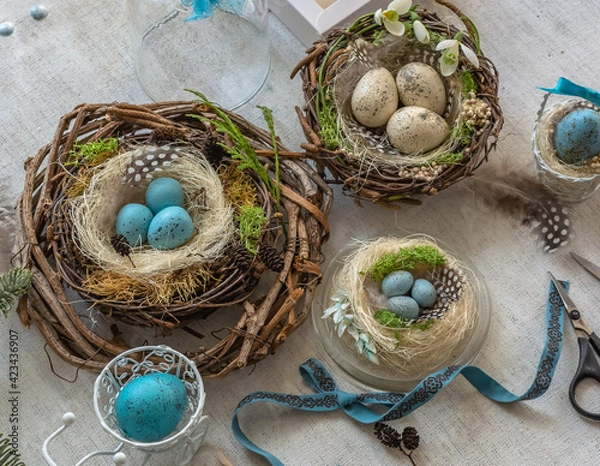 Fototapeta Pastel three colored easter eggs in the nest with cuckooflower in the background isolated on white