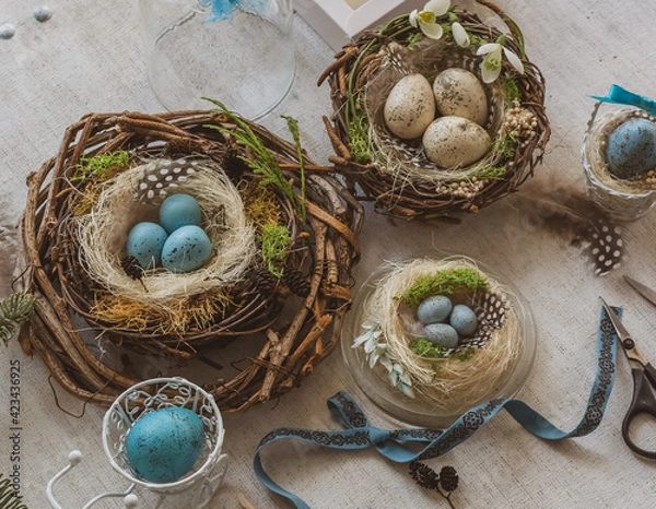 Fototapeta Pastel three colored easter eggs in the nest with cuckooflower in the background isolated on white