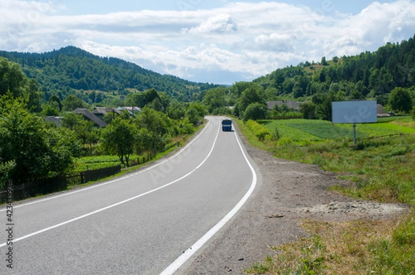Fototapeta highways in the mountains against the background of the sunny sky and the white clouds
