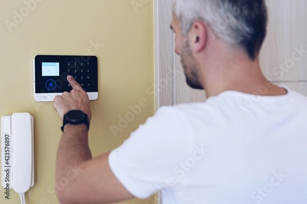 Fototapeta Man pressing buttons on control panel for disarming smart home system. Security alarm system.