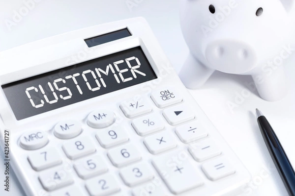Fototapeta Word CUSTOMER on calculator. Business concept on white background. Top view.