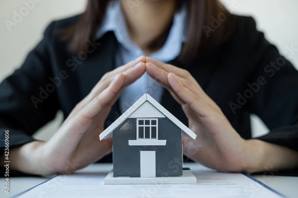 Fototapeta The house is covered by the hands of a real estate agent to protect the house for customers, homebuyers, insurance, ready give to with new owner. Home insurance sales concept
