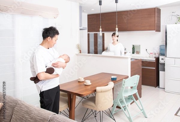 Fototapeta 赤ちゃんを抱っこする父親と見守る母親