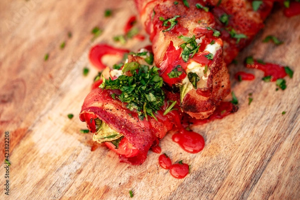 Fototapeta Sweet red pepper stuffed with cream cheese, wrapped in bacon and grilled