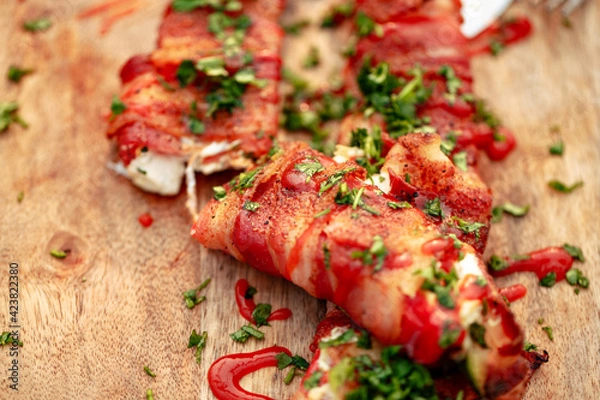 Fototapeta Sweet red pepper stuffed with cream cheese, wrapped in bacon and grilled