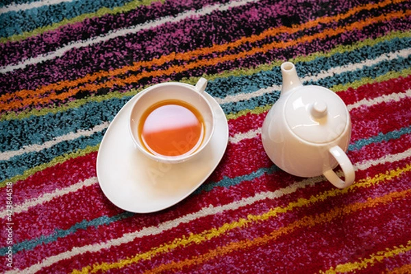Fototapeta Tea and teapot on the colorful floor