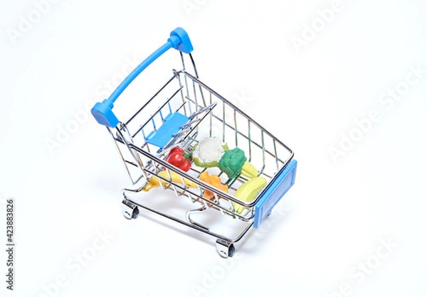 Obraz Mini cart from a supermarket with products on a white background. Top view.