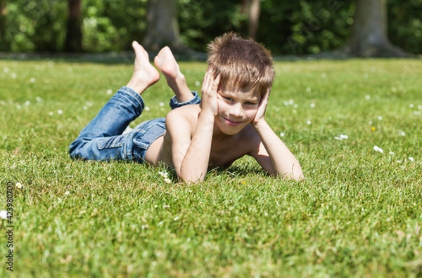 Obraz blond boy lying on grass