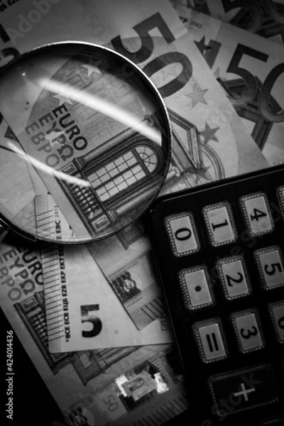 Obraz Euro bills seen through a magnifying glass and a calculator