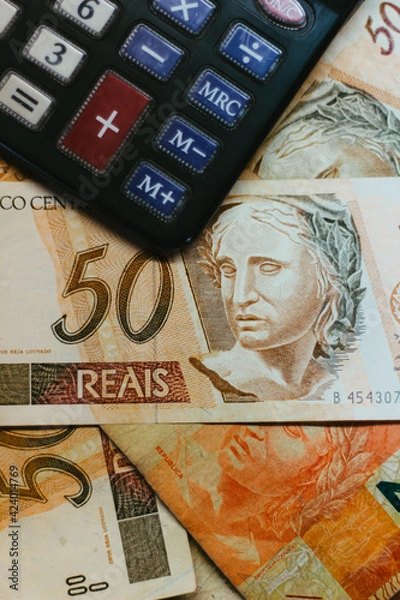 Obraz Bill of 50 Brazilian Real with a calculator and other bills under them