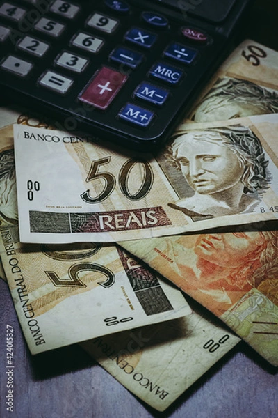 Obraz Bill of 50 Brazilian Real with a calculator and other bills under them