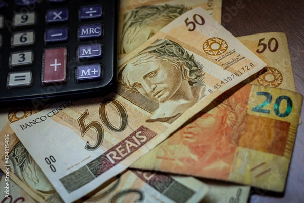 Obraz Bill of 50 Brazilian Real with a calculator and other bills under them
