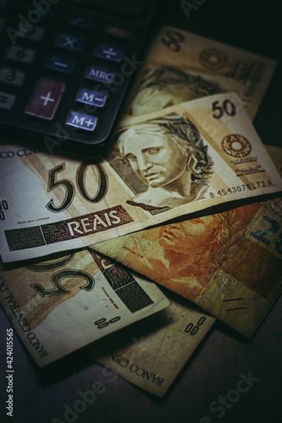 Obraz Bill of 50 Brazilian Real with a calculator and other bills under them