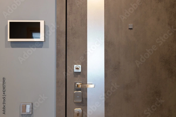 Fototapeta Shabby design entrance door in a modern apartment hallway, video intercom device on the wall. Neutral tones. Security concept, trendy interior. Horizontal