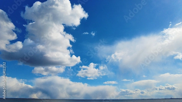 Fototapeta Bluy sky with clouds above the blue lake or river