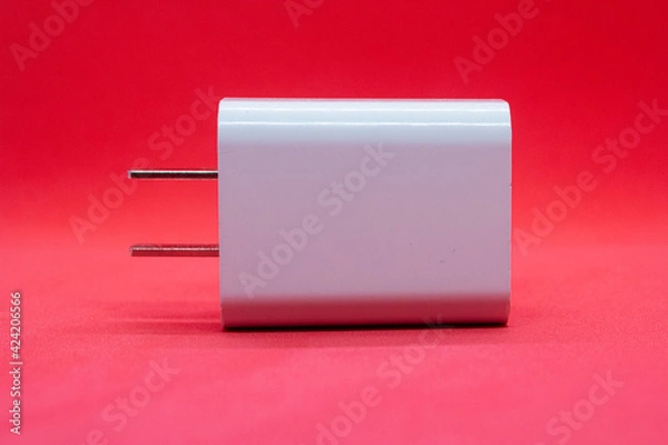 Fototapeta Separate phone charger on red background