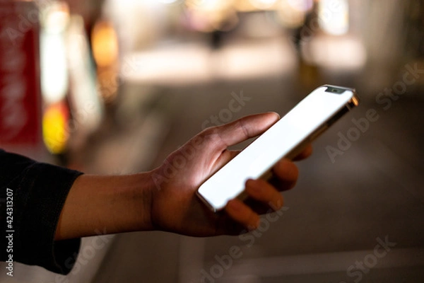 Fototapeta 道の上でスマートフォンを開く人