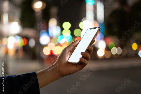 Obraz 道の上でスマートフォンを開く人