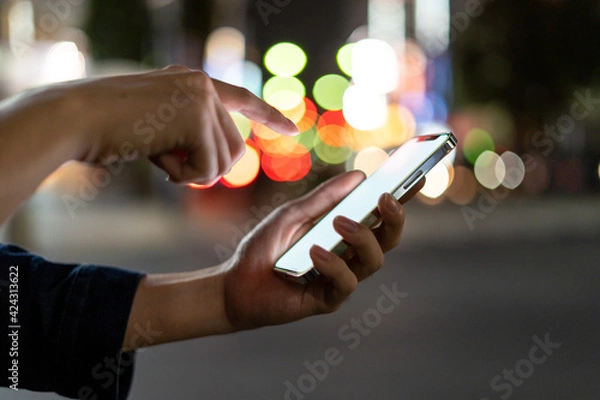 Fototapeta 道の上でスマートフォンを開く人