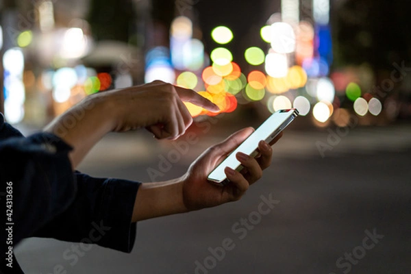 Fototapeta 道の上でスマートフォンを開く人