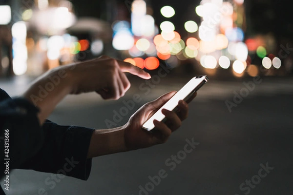 Fototapeta 道の上でスマートフォンを開く人