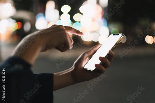 Fototapeta 道の上でスマートフォンを開く人