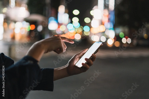 Fototapeta 道の上でスマートフォンを開く人