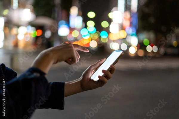 Fototapeta 道の上でスマートフォンを開く人