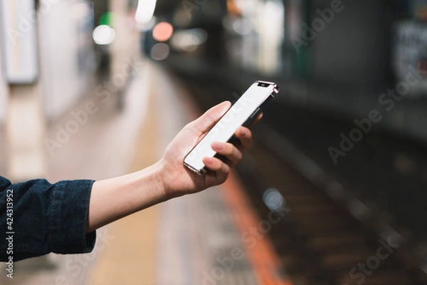 Obraz 道の上でスマートフォンを開く人