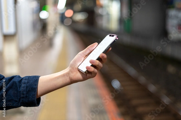 Fototapeta 道の上でスマートフォンを開く人
