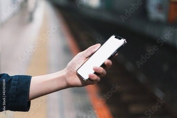 Obraz 道の上でスマートフォンを開く人