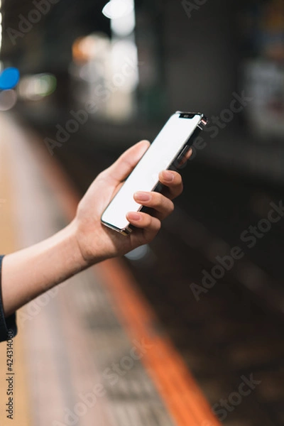 Fototapeta 道の上でスマートフォンを開く人