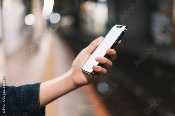 Fototapeta 道の上でスマートフォンを開く人