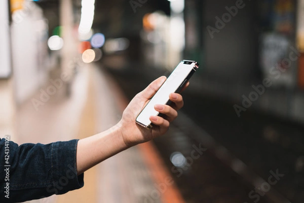 Fototapeta 道の上でスマートフォンを開く人