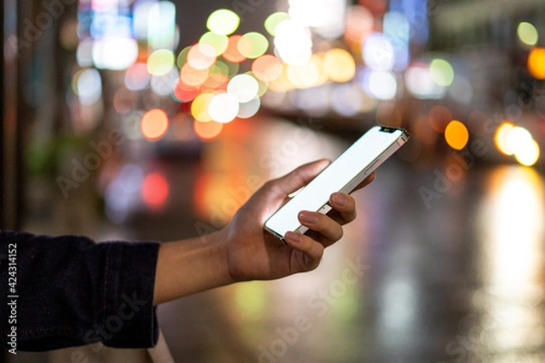 Fototapeta 道の上でスマートフォンを開く人