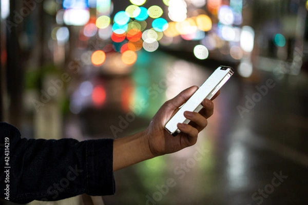 Fototapeta 道の上でスマートフォンを開く人